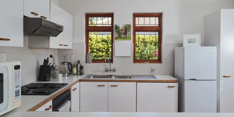 A bright white kitchen with a lowered counter section, open knee space beneath the sink and deep pull out drawers.