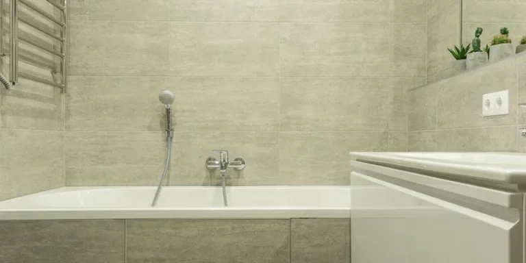 A powered bath lift seat lowered inside a white bathtub with its waterproof hand controller resting on the tub rim.