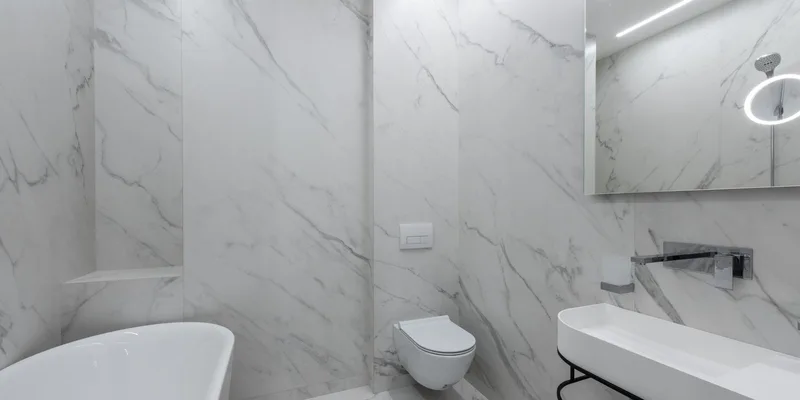 A white raised toilet seat clamped onto a toilet bowl in a clean bright bathroom.