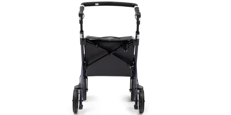 A four wheeled rollator with a padded seat and loop hand brakes parked in a bright entry hall.