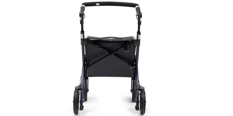 A four wheeled rollator with a padded seat and loop hand brakes parked in a bright entry hall.