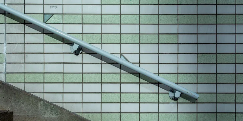 A bathroom with grab bars mounted beside the toilet, at the shower entry and along the tub wall.