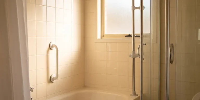 A suction grab bar and a tension mounted pole in a rental bathroom with no drilled holes.