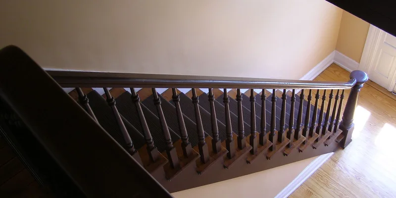 An indoor staircase with added stair treads, a second handrail and a plug in night light.