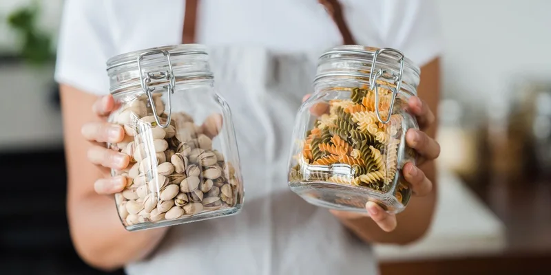 An under cabinet jar opener and a rubber grip pad on a kitchen counter beside a closed jar.