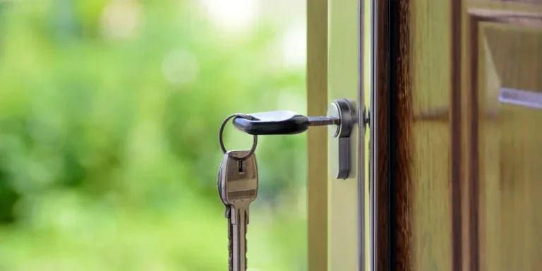 A key fitted with a moulded turner grip in a front door lock below a lever handle.