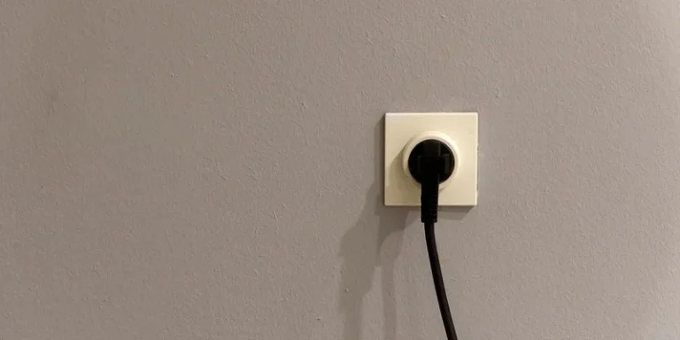 A plug inserted into a wall socket at home.
