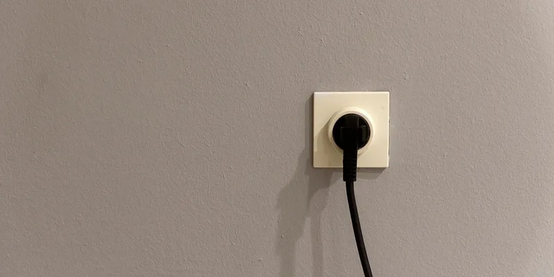A plug inserted into a wall socket at home.