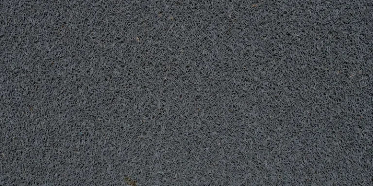 A suction bath mat inside a tub and a rubber backed mat on the floor beside it.