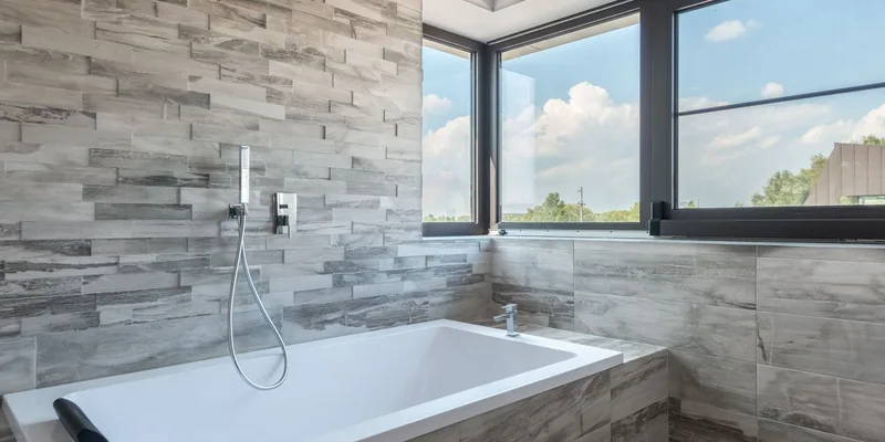 A transfer bench with a backrest straddling a bathtub rim.