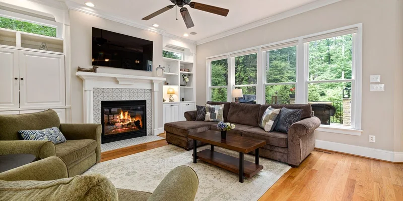 A living room floor with a curled rug edge, a trailing lamp cord and a raised threshold.