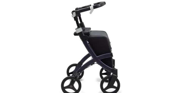 An upright rollator with padded forearm platforms standing in a bright hallway.