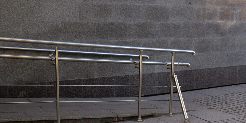 A ramp with railings on both sides curving to a landing at a home entrance.